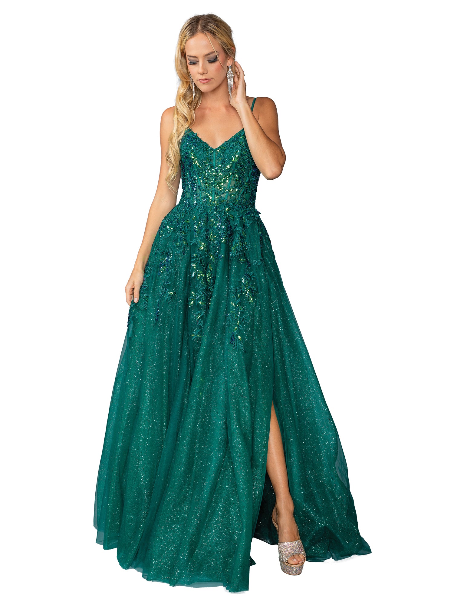 A woman in the Long Glitter Prom Ball Gown: Dancing Queen 4452—a sleeveless, floor-length emerald green A-line dress with floral embellishments, a front slit, and a lace-up open back—stands against a white background.